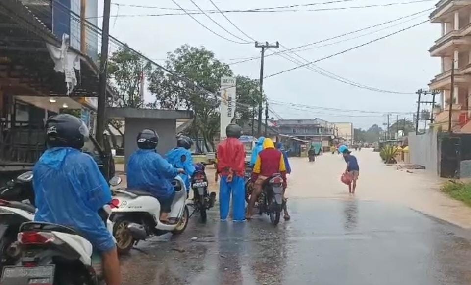 Warga yang menerobos banjir. Foto: Sorotanbangka.