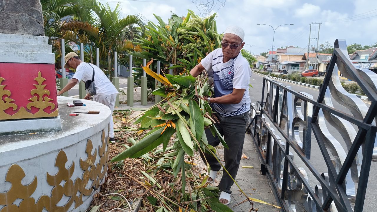 Yus Derahman membersihkan Tugu Duren Mentok. Foto: Rizki Ramadhani.