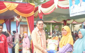 Markus saat membagikan sembako murah ke warga. Foto: Istimewa.